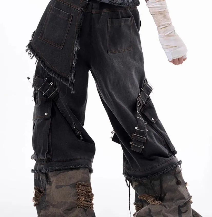 Men's grey cotton jeans with camouflage print, splicing panels, and decorative pin and ribbon details.