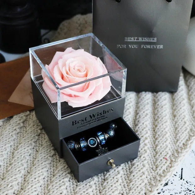 Glass eternal flower jewellery box with preserved roses and carnations inside measuring 8.5cm square