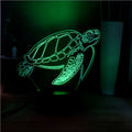 3D acrylic turtle-shaped LED night light with remote control on a table