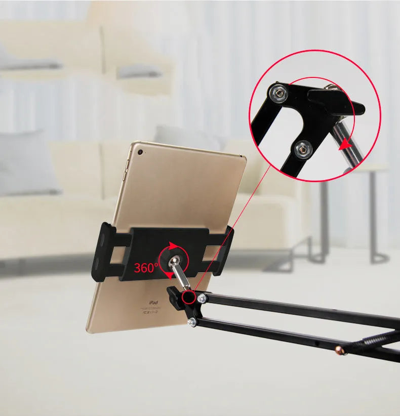 Black adjustable phone tablet stand with 360-degree rotating head on wooden desk