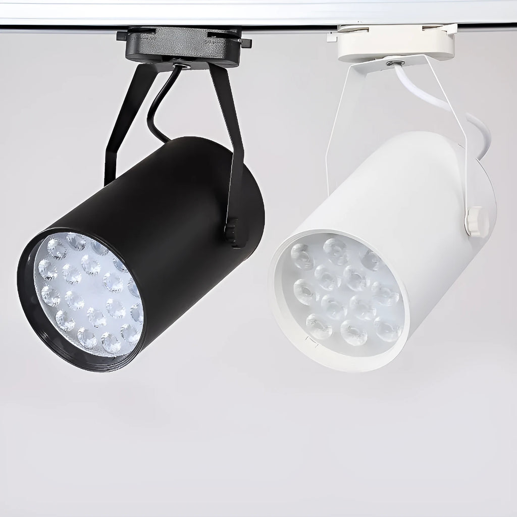 A black aluminium LED track spotlight mounted on a lighting track, angled to illuminate a wall.