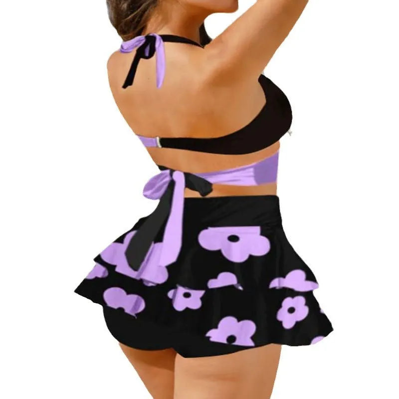 Women's purple lace-up high waist bikini set with matching swim skirt laid flat.