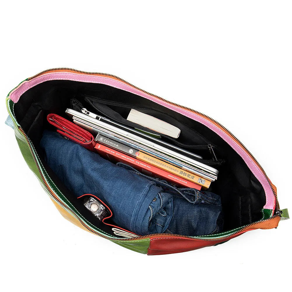 Brown cowhide leather crossbody shoulder travel bag with stitching detail, shown with a laptop and magazine inside.