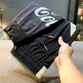 Black men's cropped trousers with banded ankle made from ice silk and cotton fabric.