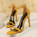 Open toe high heel shoe with an ankle strap and buckle, shown in a solid colour.