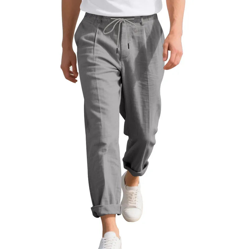 Men's loose-fit linen trousers in light khaki colour with a drawstring waistband.
