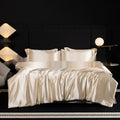 Silk four-piece bed sheet set in solid colour on bed with matching pillowcases and quilt cover