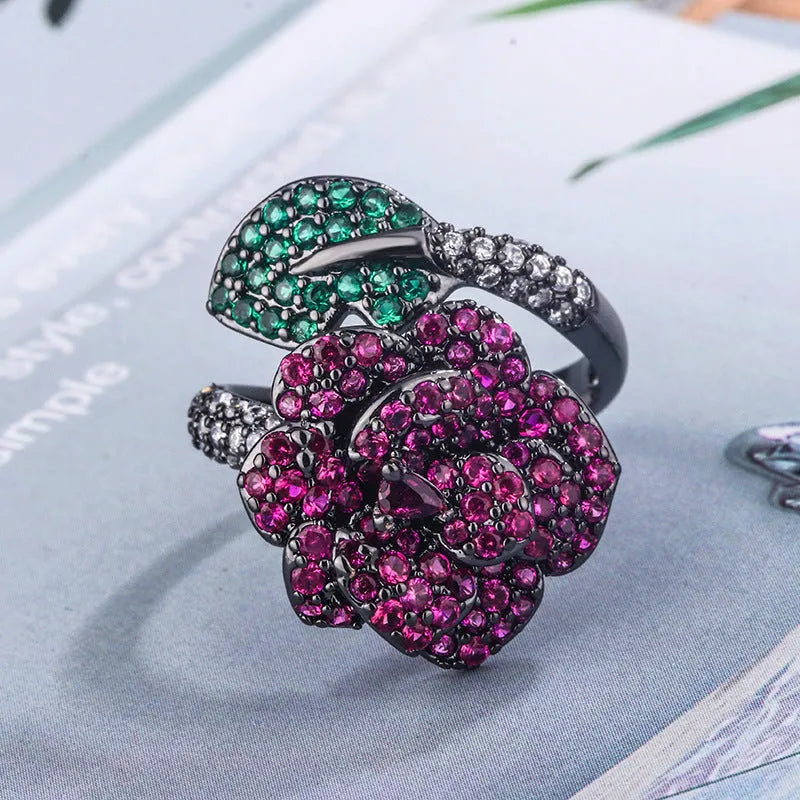 Gold-plated copper women's ring with geometric flower design and simulated red corundum in black gold colour.