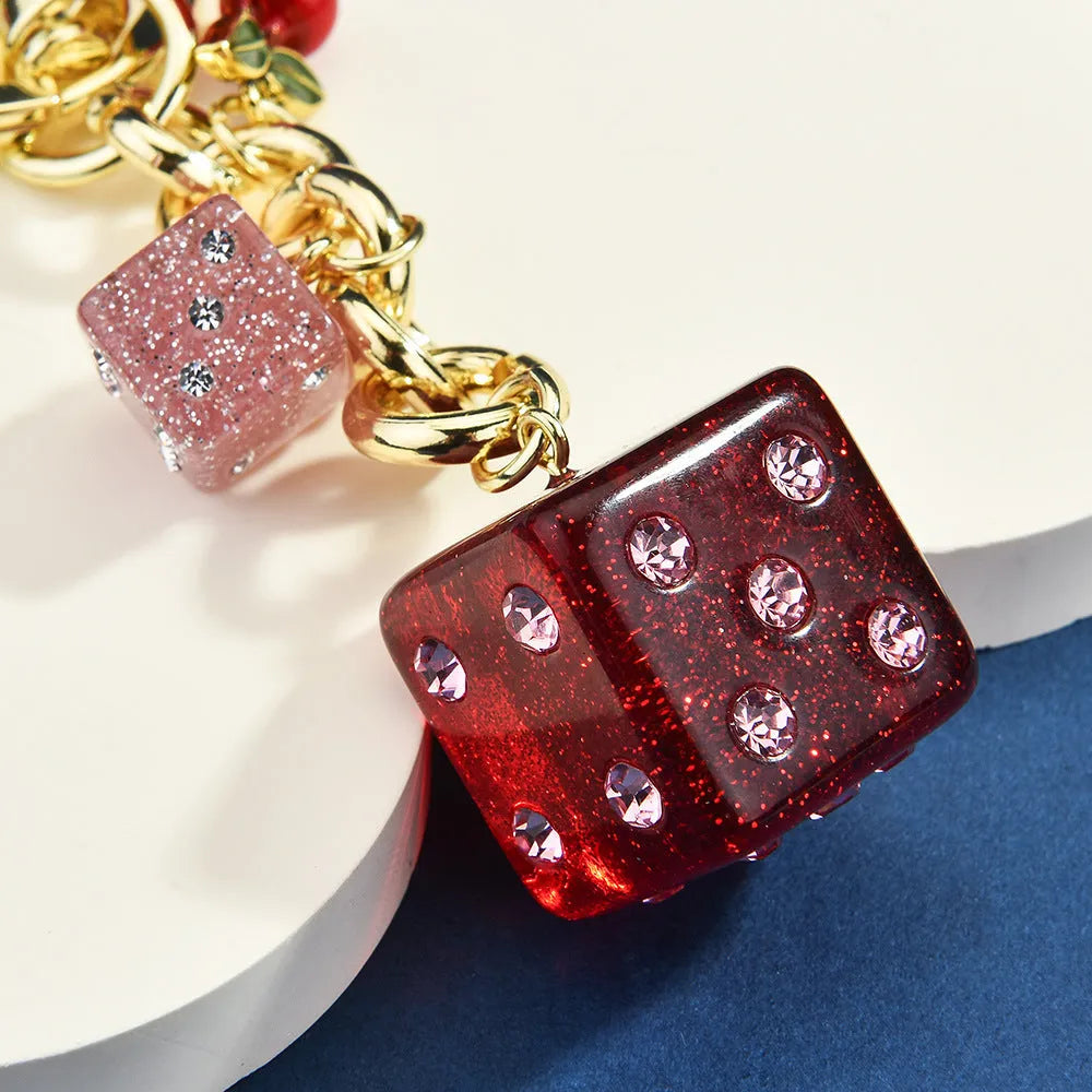 Square metal keychain pendant with a vintage cherry red and white dice design.