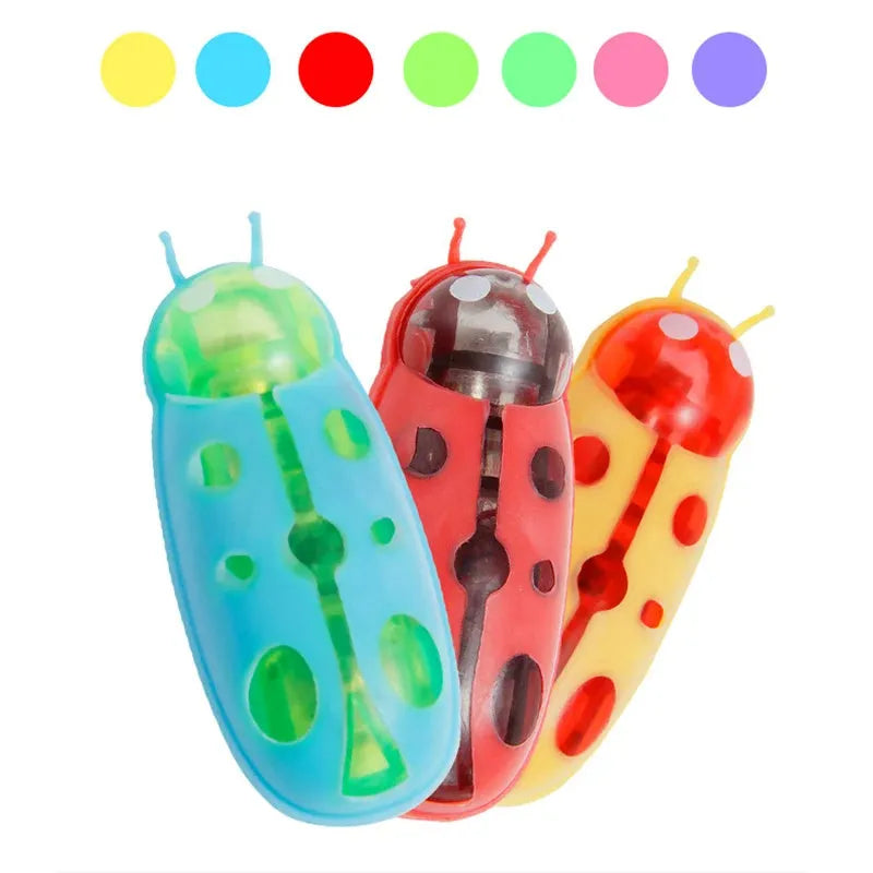 Small red ladybird-shaped electric cat toy with multiple legs on a hardwood floor