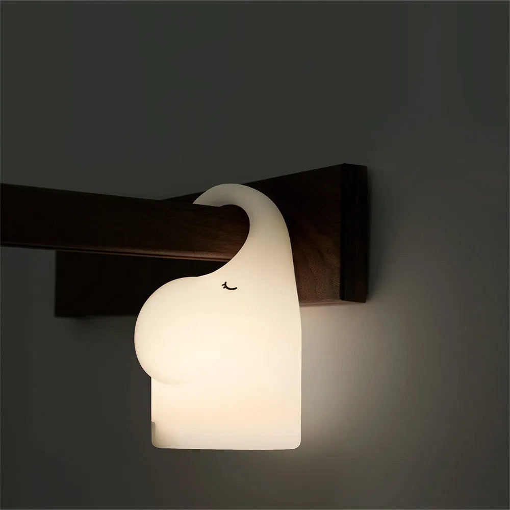 Elephant shaped silicone night light with warm 3000k LED glow on a bedside table