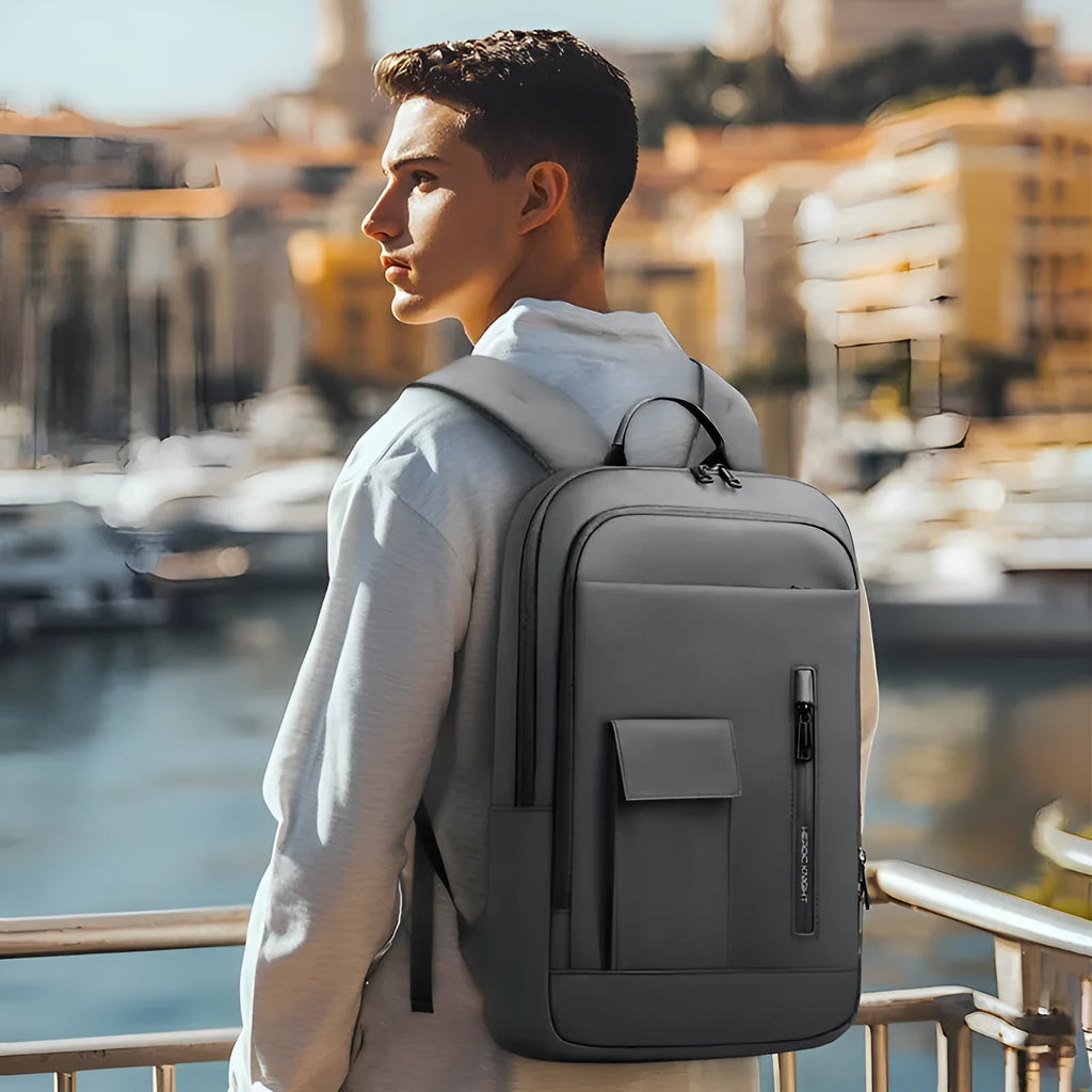 Men's lightweight Oxford cloth backpack in dark grey, shown from the side with visible sewing line details.