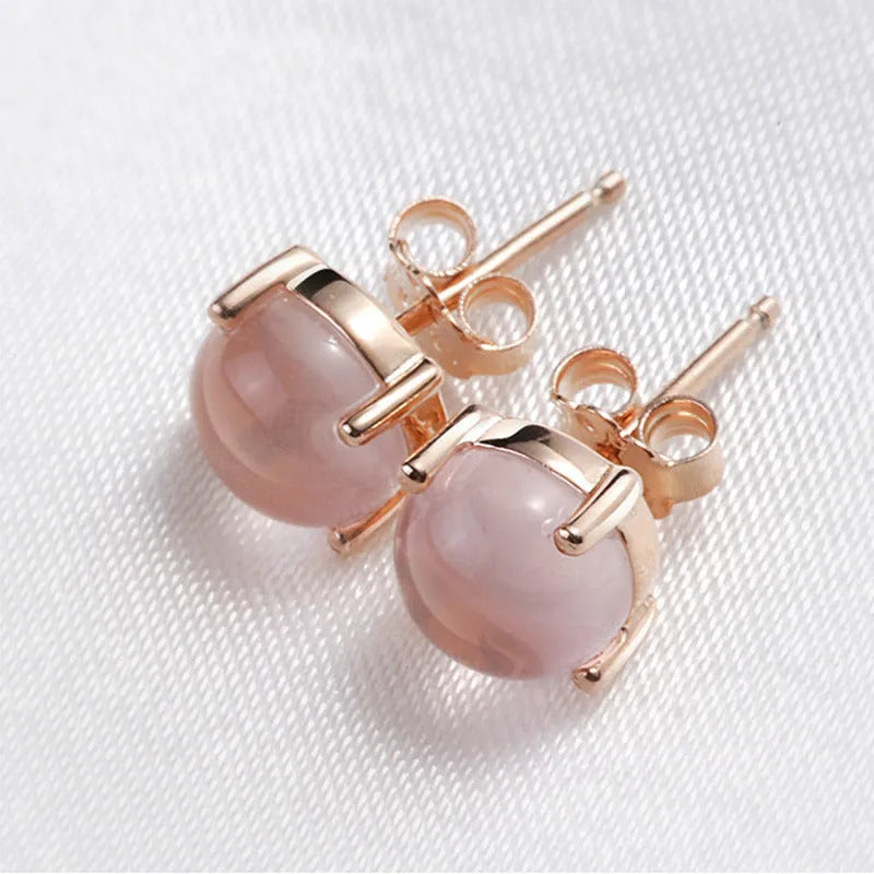 Close-up of women's drop-shaped synthetic quartz stud earrings with a rose gold finish.
