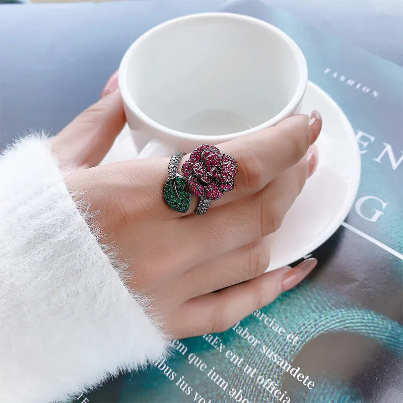 Gold-plated copper women's ring with geometric flower design and simulated red corundum in black gold colour.