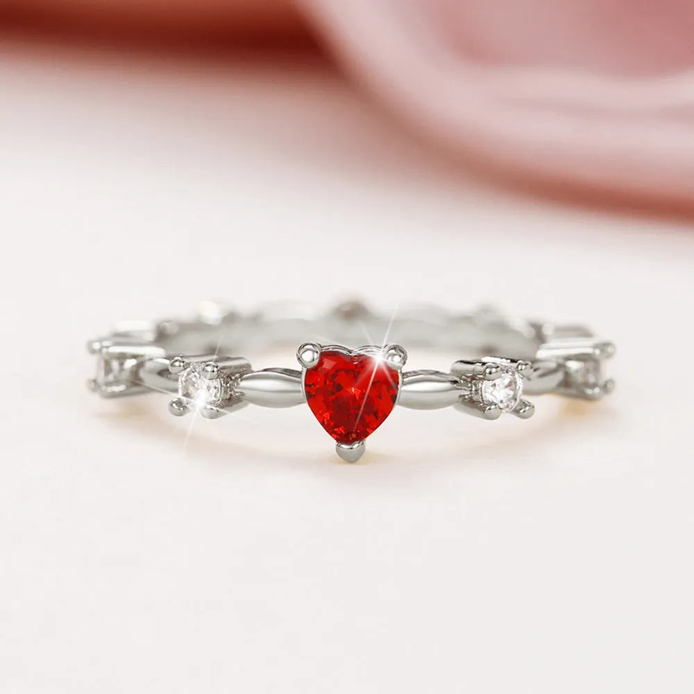 Gold or silver electroplated peach heart ring with zircon stones on a model's hand