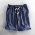 Man wearing black and white striped cotton casual shorts with a loose straight fit.