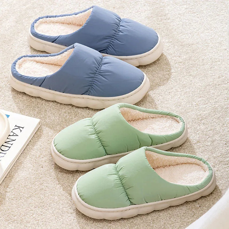 Blue winter indoor slippers with thick rubber sole and plush lining, shown on a hard floor.