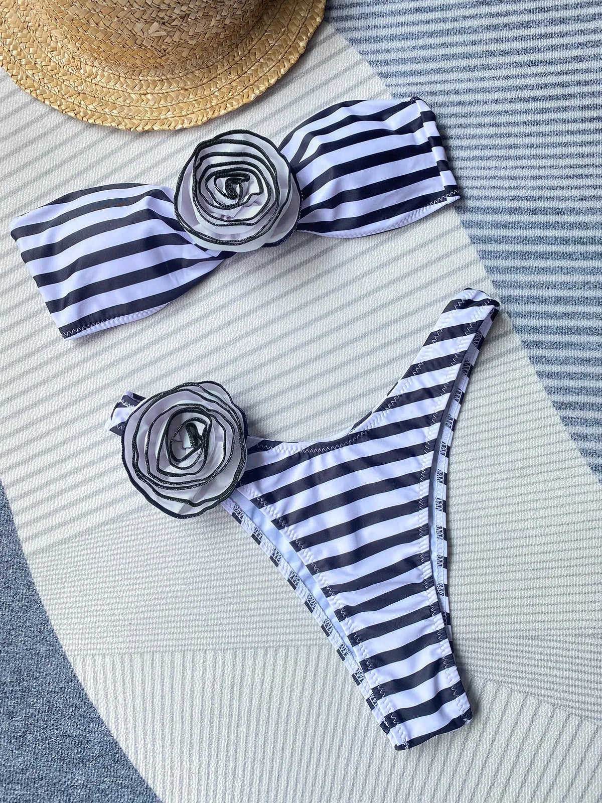 Black bikini with cross-back tube top and high-split shorts featuring three-dimensional floral details