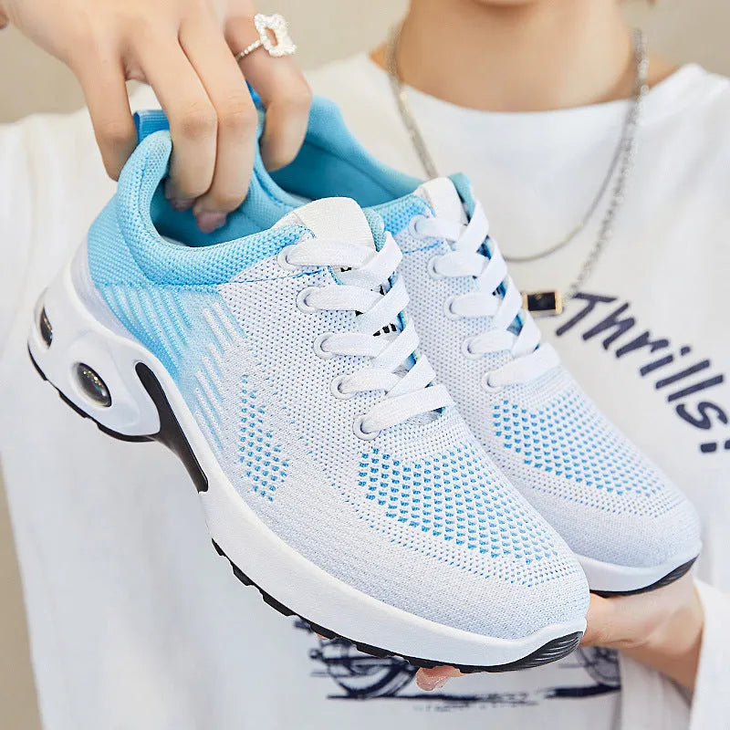 Women's pink Flyknit casual running shoes with mesh lining and flat PVC sole on a white background.