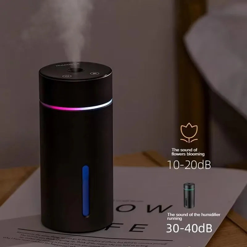 Black aluminium car humidifier and essential oil diffuser with night light on a desk.
