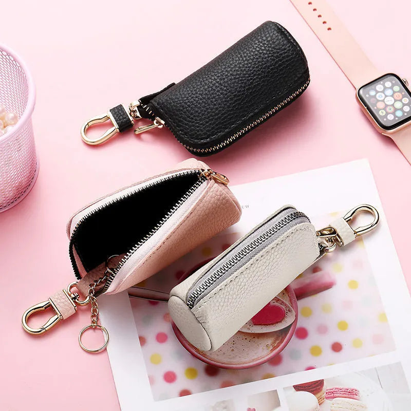 Simple black PU leather zipper key ring for car keys on a grey background.