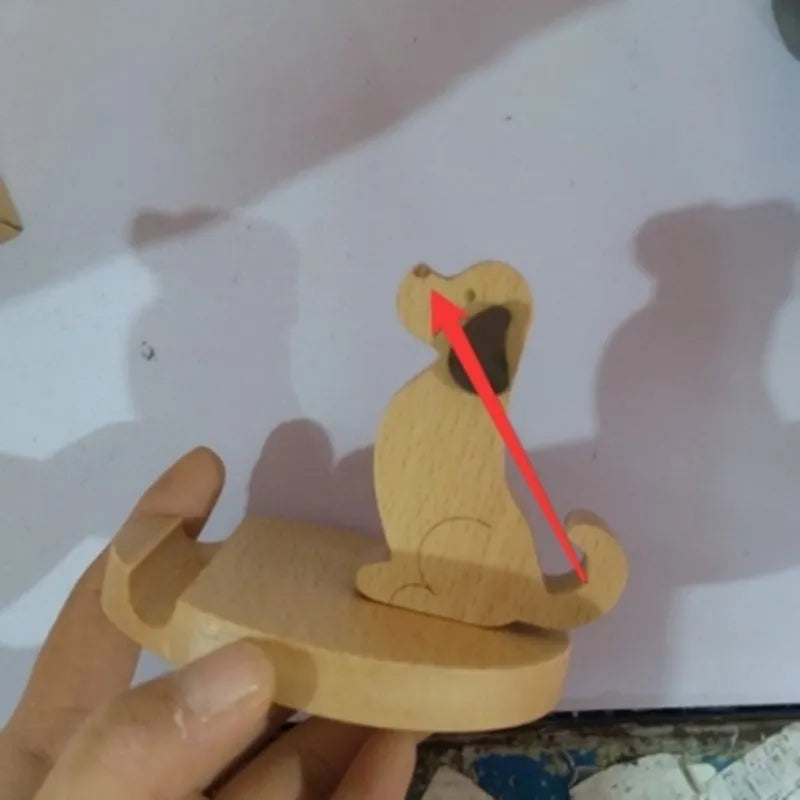 Solid beech wood mobile phone stand with a decorative resin animal ornament and a coin slot.