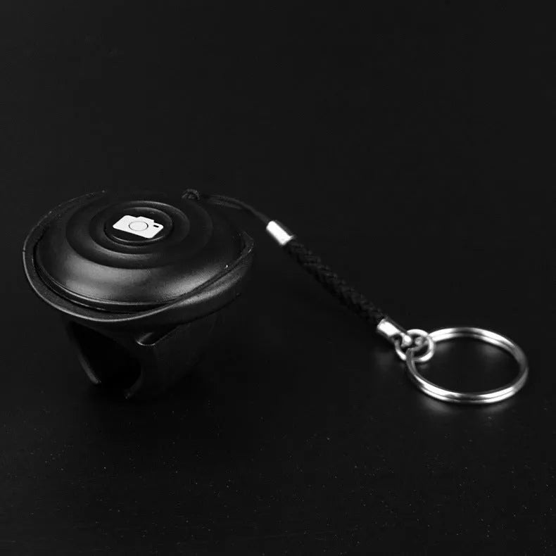 Black Bluetooth remote selfie shutter for smartphone photography with wireless operation