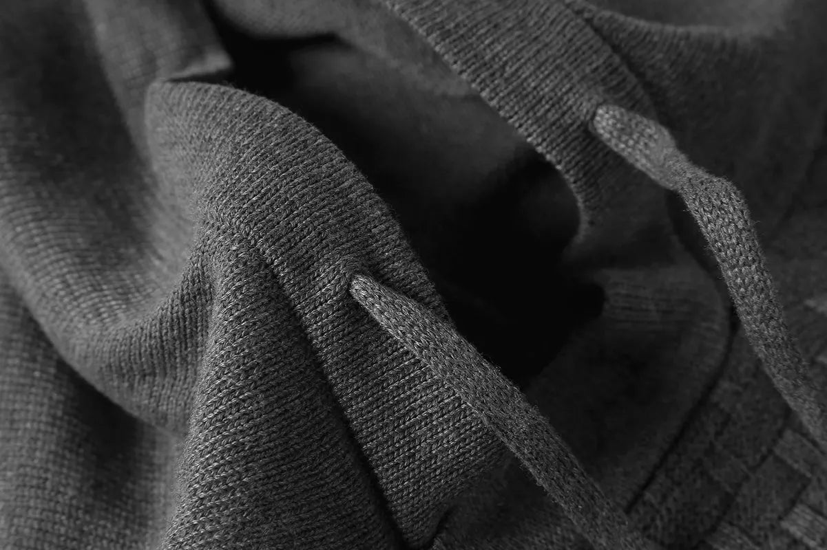 Men's black hooded sweatshirt made from cotton and polyester blend fabric on a grey background.