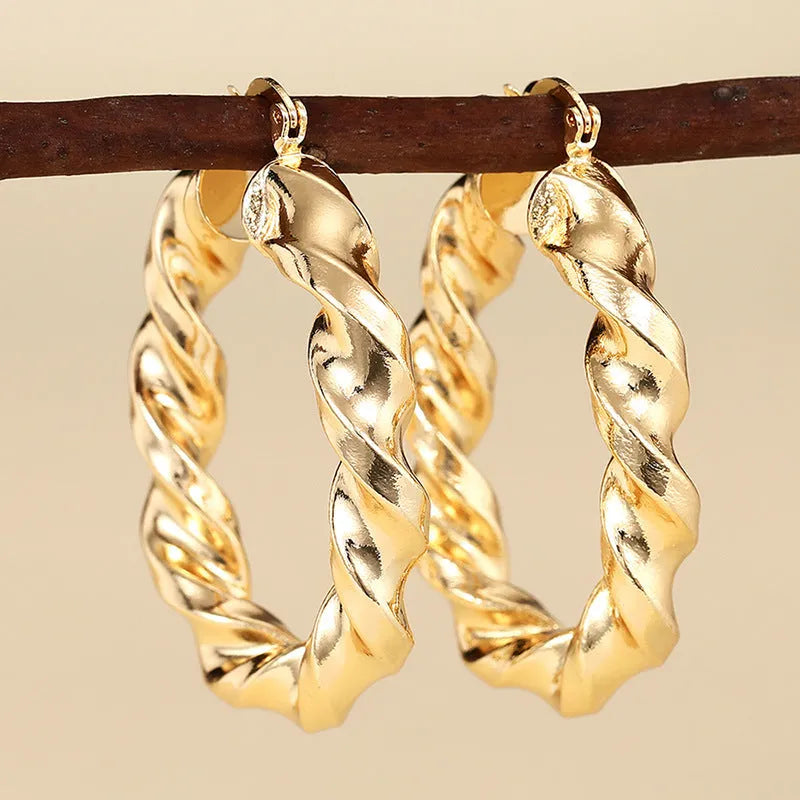 Geometric drop-shaped women's ear clip with ring design in electroplated copper.