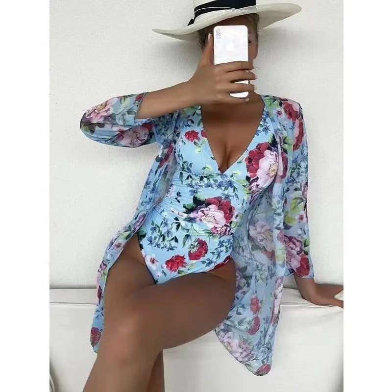 Women's floral patterned bikini three-piece set with a matching coat on a hanger