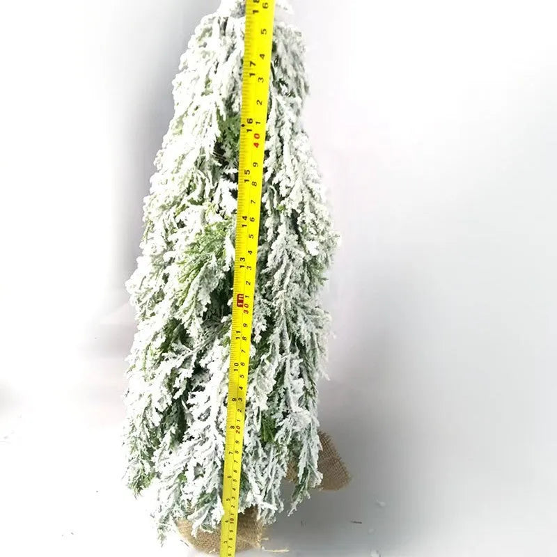 24-inch artificial Christmas tree with snow spray finish and integrated lights on desktop