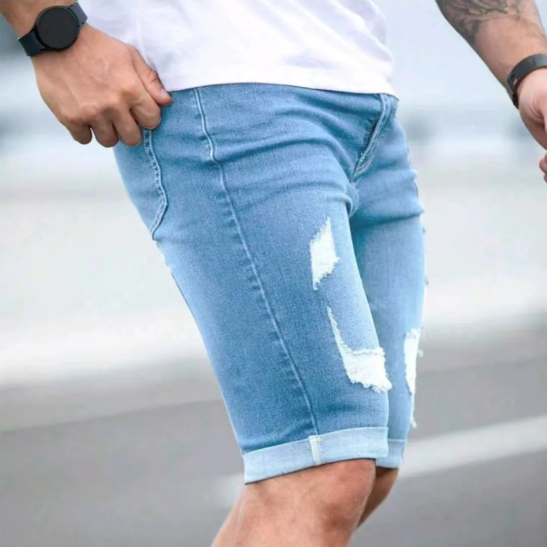 Men's sky blue denim shorts with multi-hole distressed design showing low waist and straight cut