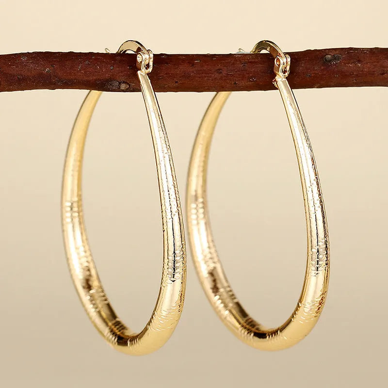Geometric drop-shaped women's ear clip with ring design in electroplated copper.