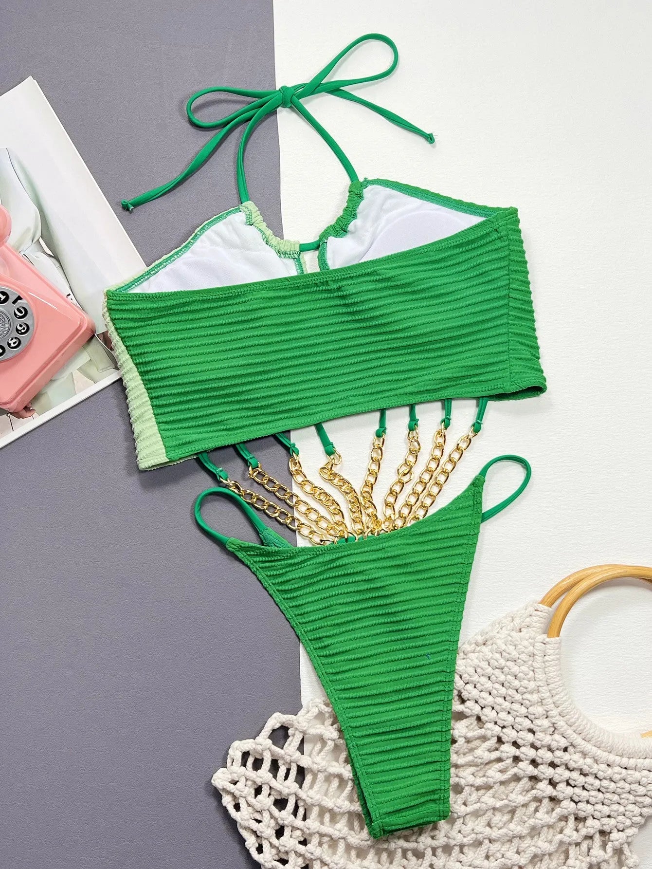 Green women's one-piece swimsuit with hollow out design on a mannequin, showing front and back views.