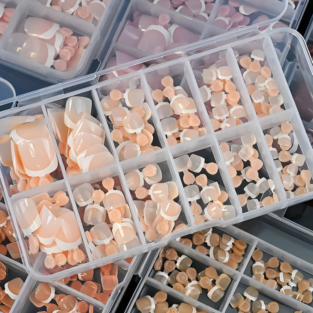 120 piece box of square short French style artificial toe nails with white tips on nude base.