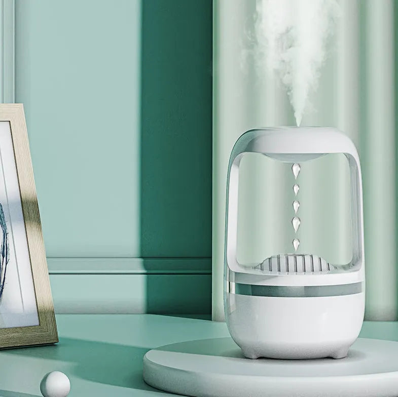 White anti-gravity humidifier with upward-flowing water droplets on a desk