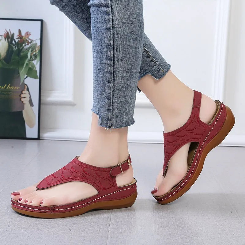 Women's black wedge heel sandals with an adjustable back strap buckle on a white background.