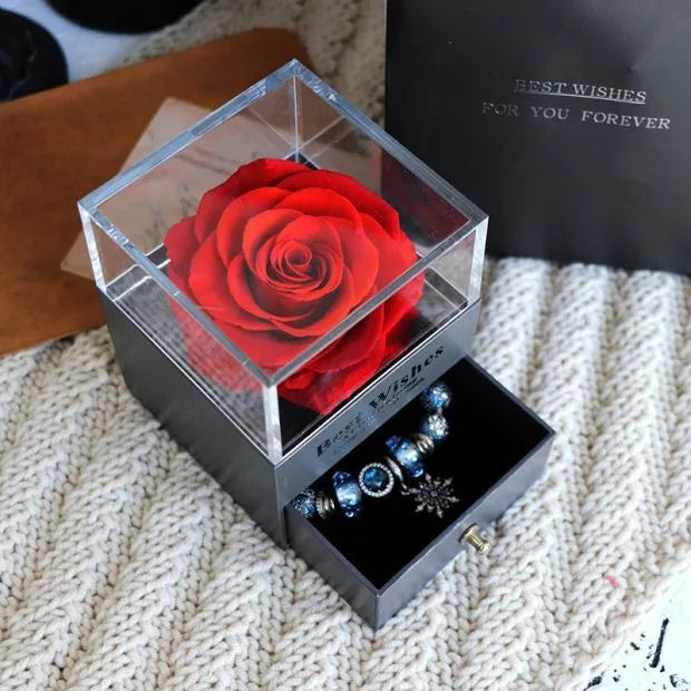 Glass eternal flower jewellery box with preserved roses and carnations inside measuring 8.5cm square