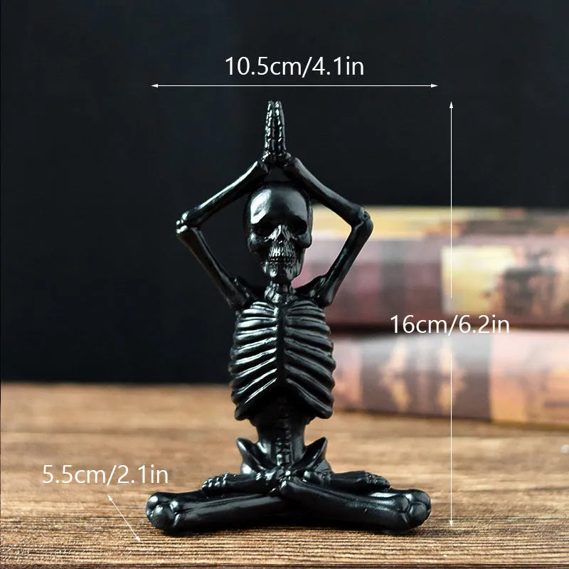 Detailed resin Halloween ornament of a yoga-posing skeleton skull on a desktop.