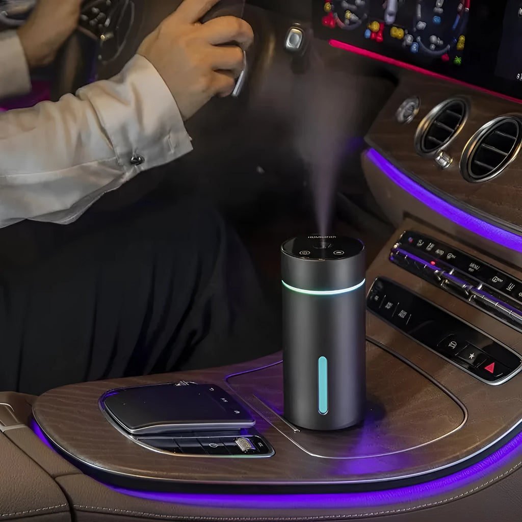 Black aluminium car humidifier and essential oil diffuser with night light on a desk.