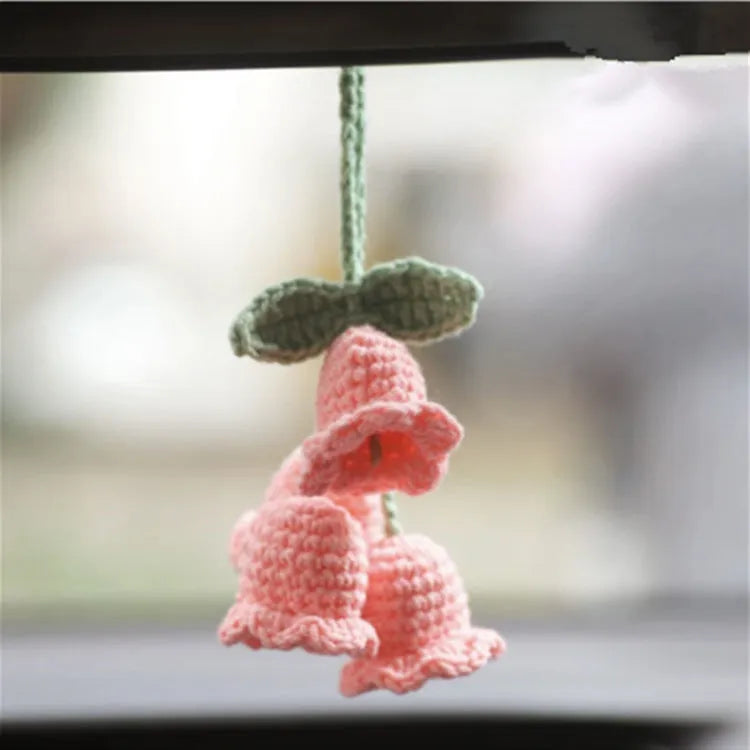 Green and white knitted wool car plant decoration basket with white hanging cord.