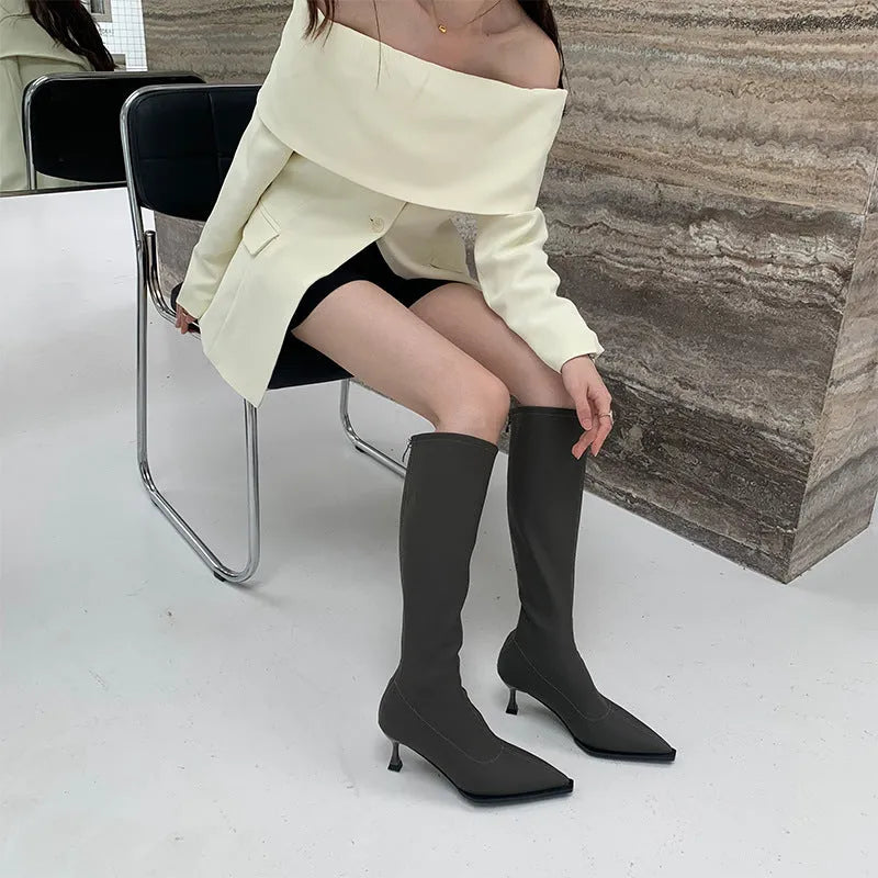 Black women's below knee pointed toe stiletto heel boots with a back zipper