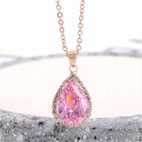 Water drop shaped pendant necklace with geometric design and rhinestone accents in pink colour