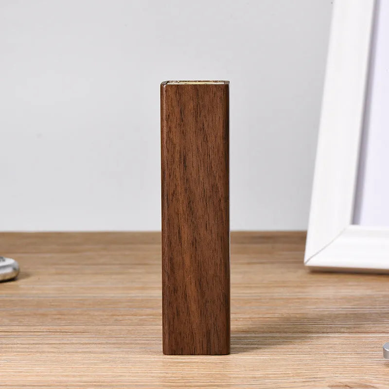 Brown walnut wood portable power bank with USB port next to its gift box.