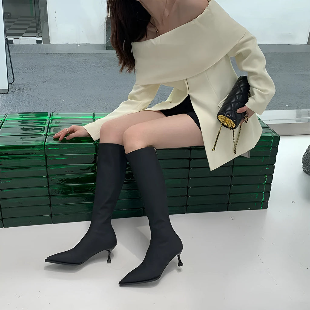 Black women's below knee pointed toe stiletto heel boots with a back zipper