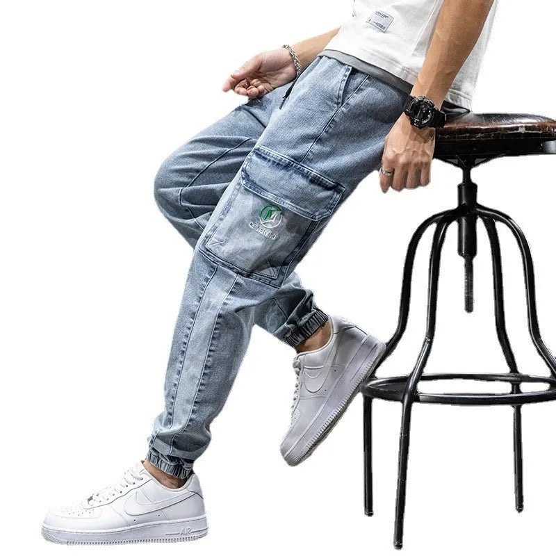 Men's loose-fit cargo jeans in blue, showing straight leg and mid-waist design on a hanger.