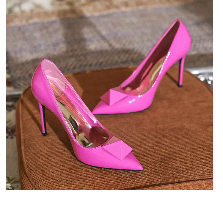 Women's pink patent leather stiletto heels with pointed toe and buckle fastening