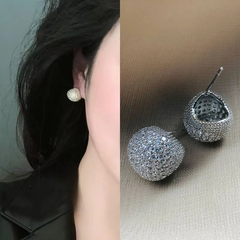 Gold geometric drop earrings with diamond patterning and sphere elements