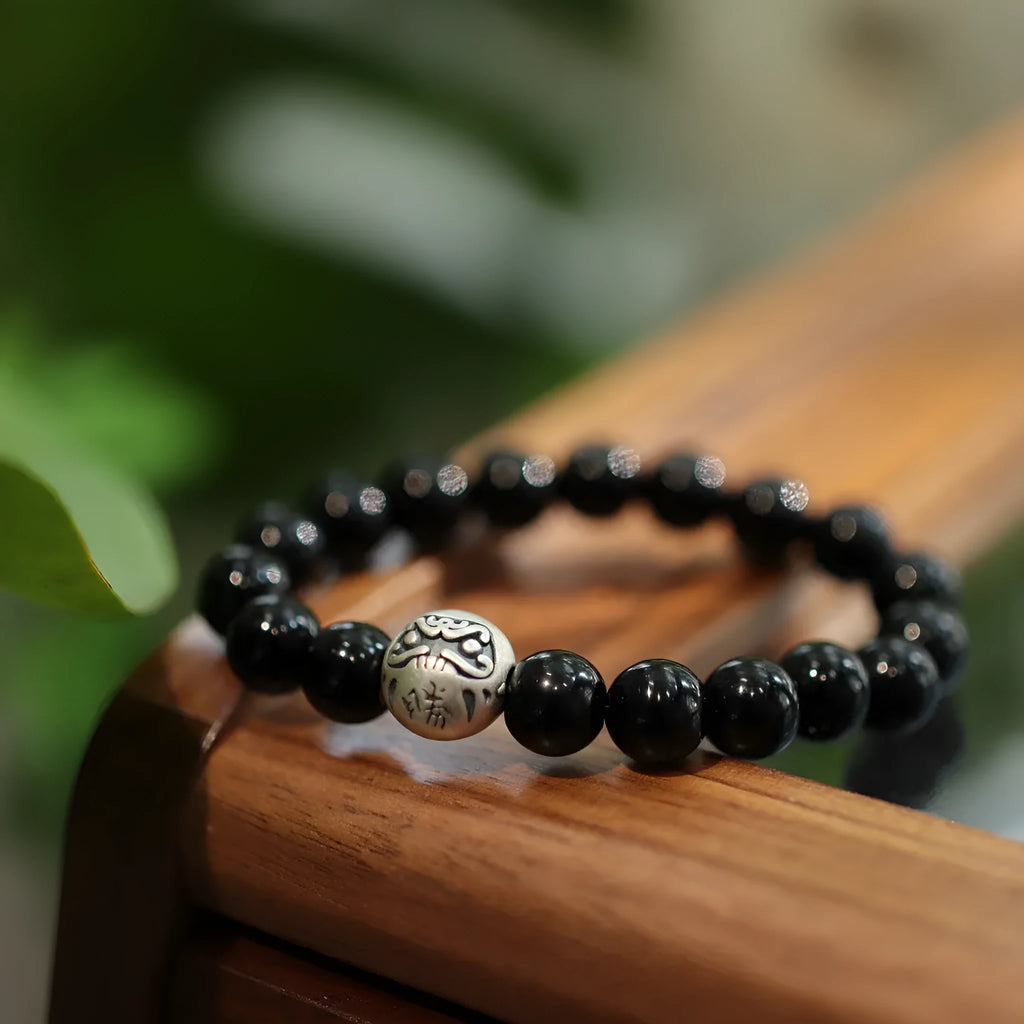 Close-up of a black agate and sterling silver bracelet showing 10mm beads and detailed clasp.