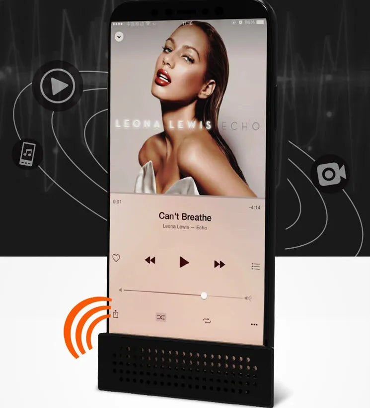 Pink portable ABS mobile phone amplifier bracket holding a smartphone horizontally on a desk.